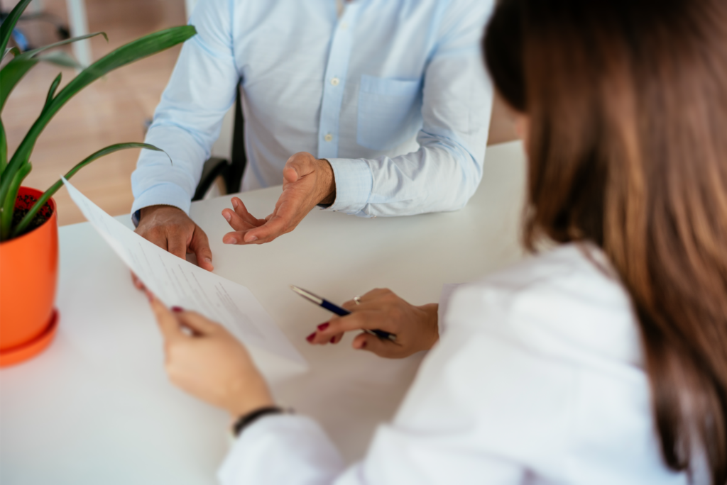 Two people speaking about a piece of paper.