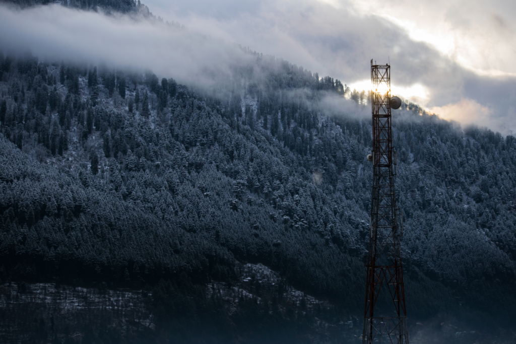 Satellite tower against snowy mountain background.